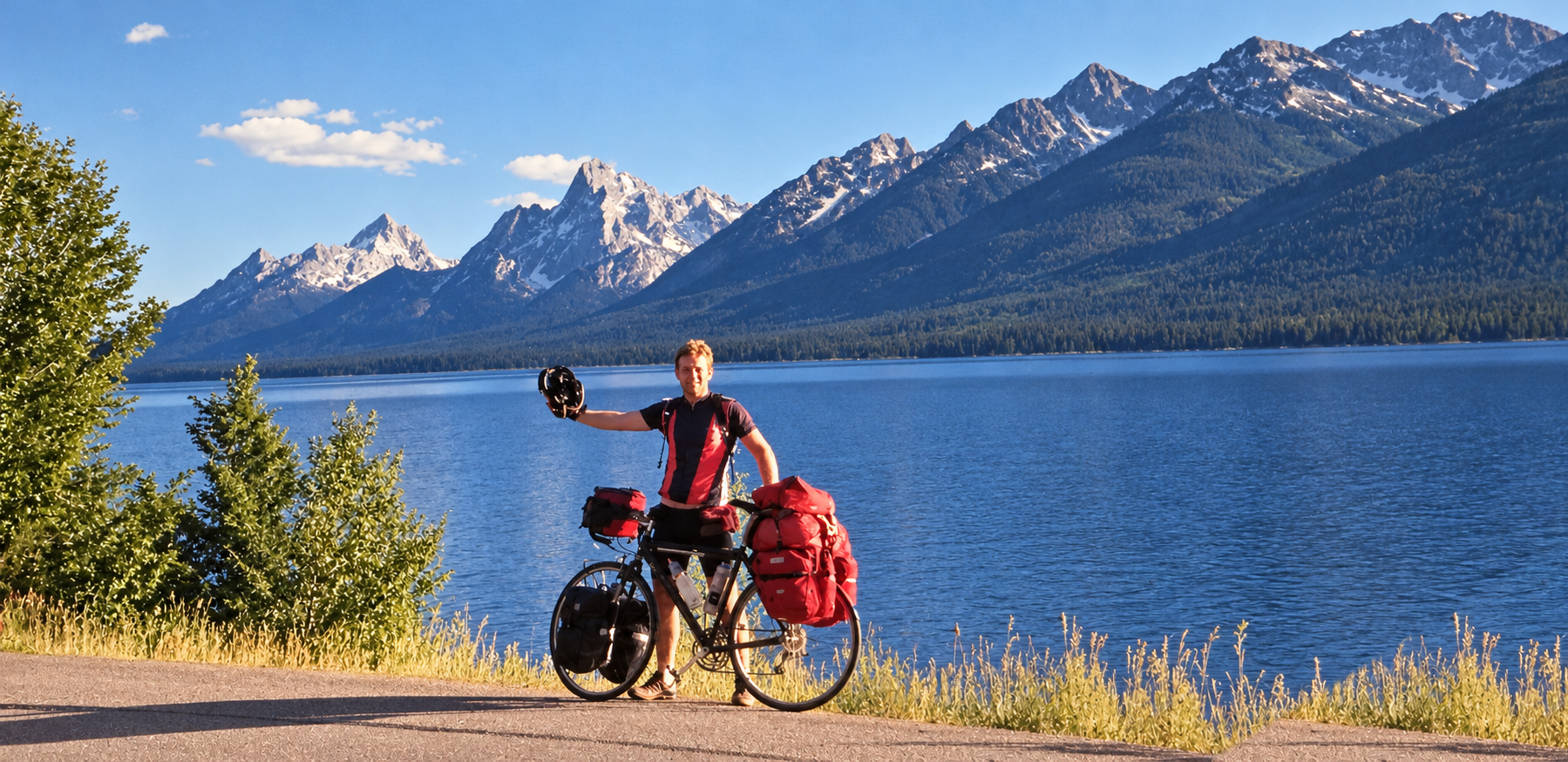 Sam Morris with his loaded touring bicycle beside a lake in the Grand Tetons, during his cross-country cycling trek